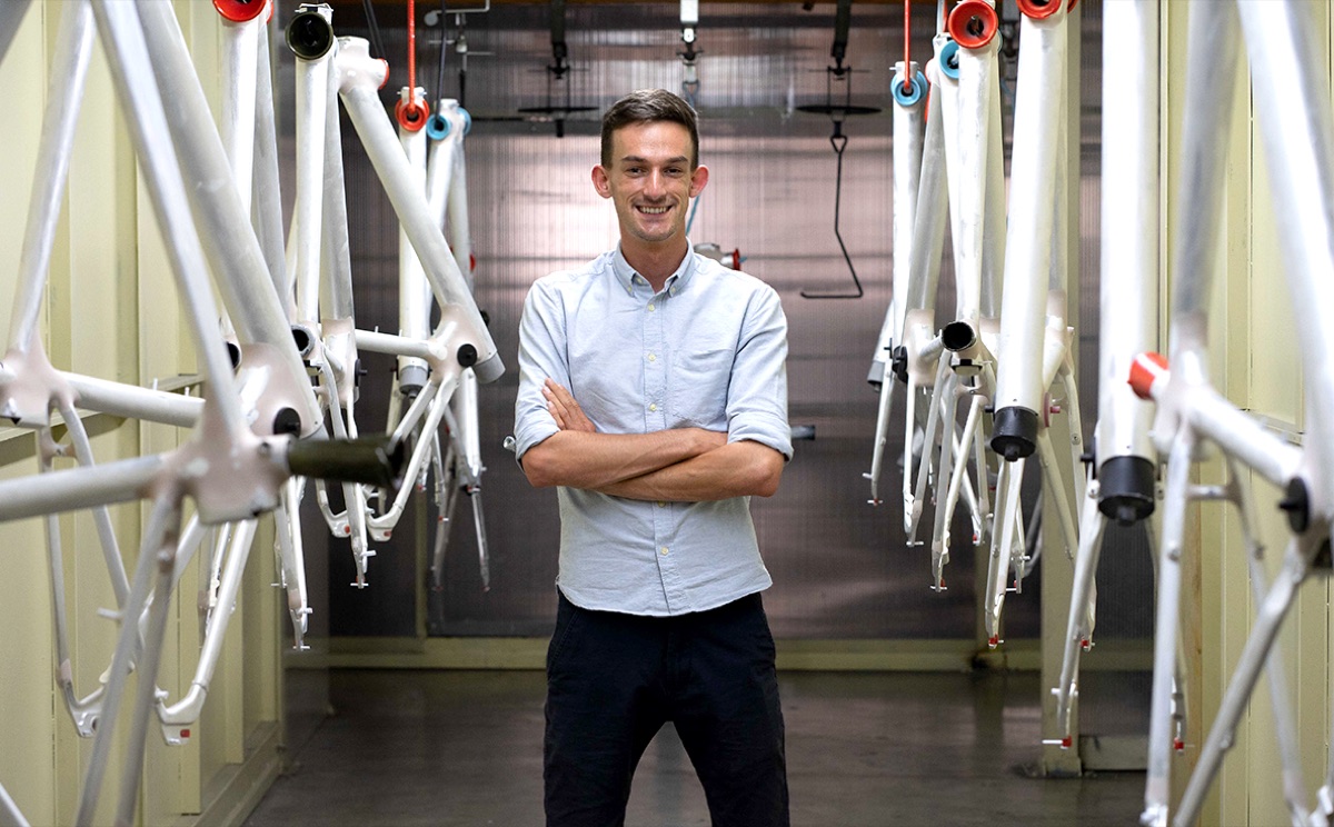 Jack O'Sullivan standing among Modmo bike frames in the factory